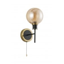 single wall light in brass and black with round amber glass shade