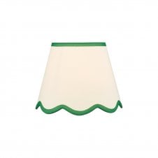 A neutral scalloped edge table lamp shade with green accent edging