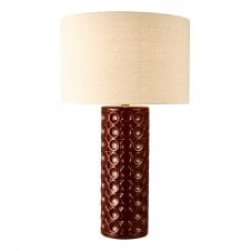 a large red ceramic table lamp with dimpled detail and ivory linen drum shade 