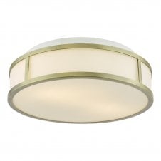 An art deco inspired flush bathroom ceiling light with aged brass frame and opal glass shade